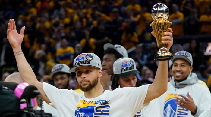 Golden State Warriors’ Stephen Curry holds up the conference finals MVP trophy after the Warriors defeated the Dallas Mavericks in Game 5 of the NBA basketball playoffs Western Conference finals in San Francisco, Thursday, May 26, 2022.